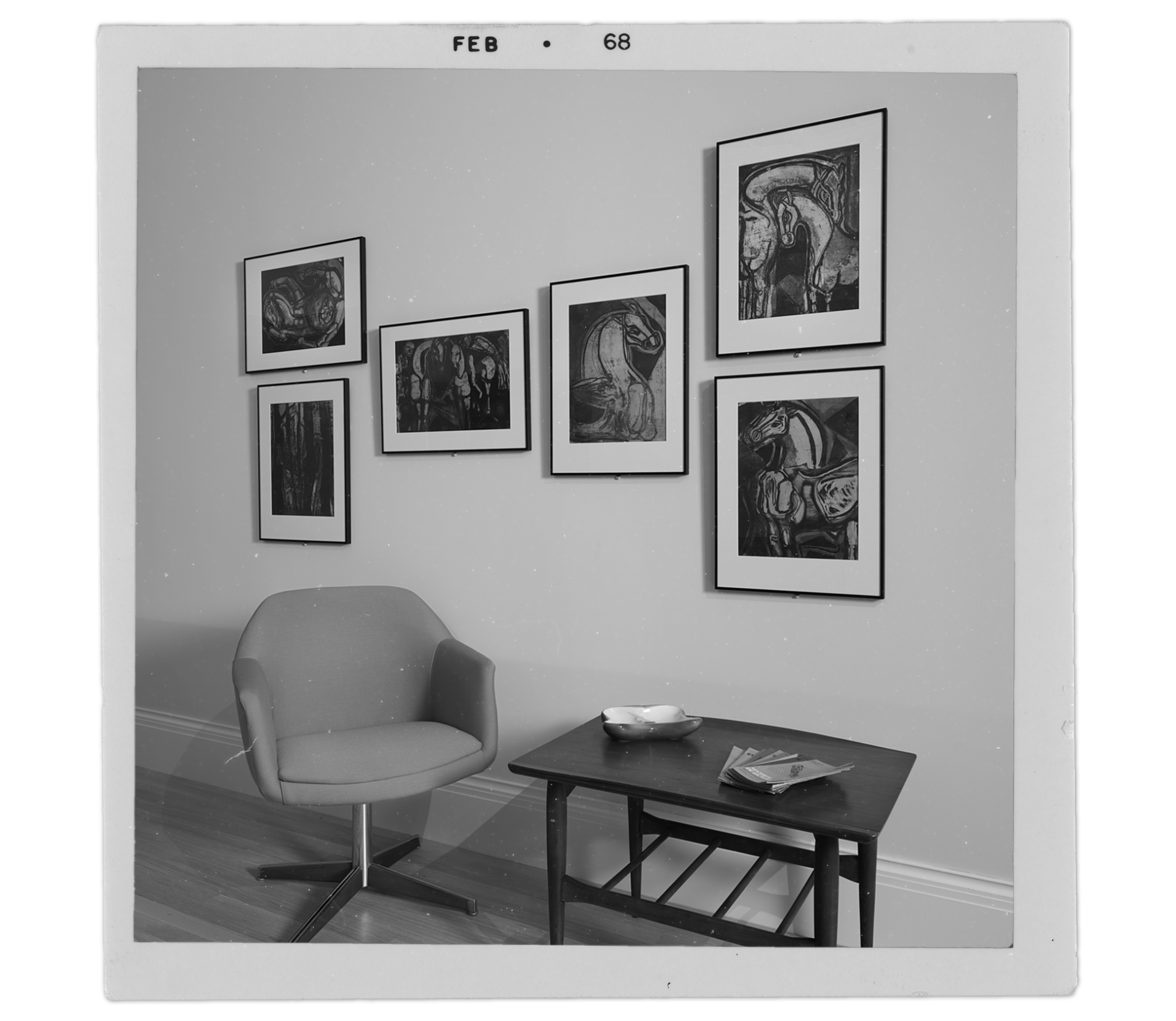 "Old" photograph of six Delia del Carril prints hanging on a wall above a midcentury chair and table