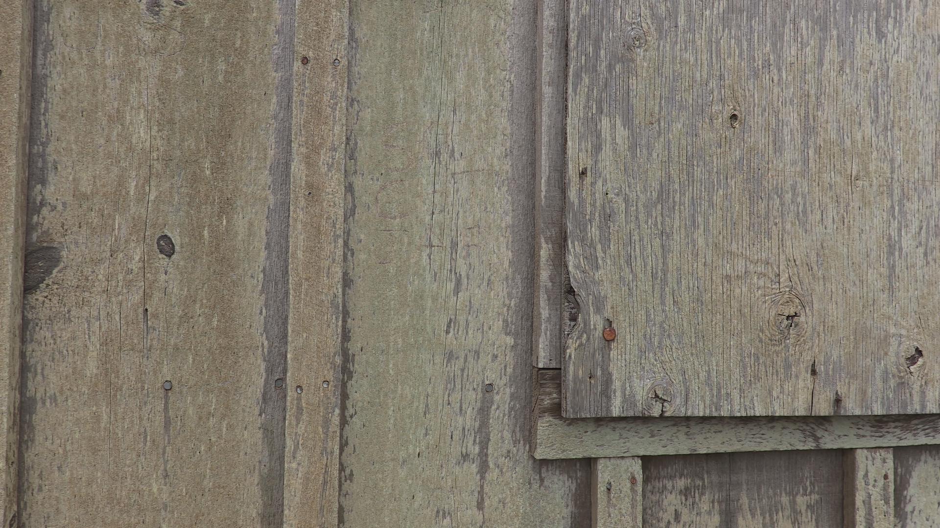 Wooden slats are shown close-up in a detail shot with weathered and rusty nails and fastners.
