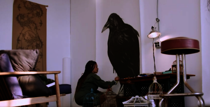 artist sabrina nelson adjusts an image of a large black bird