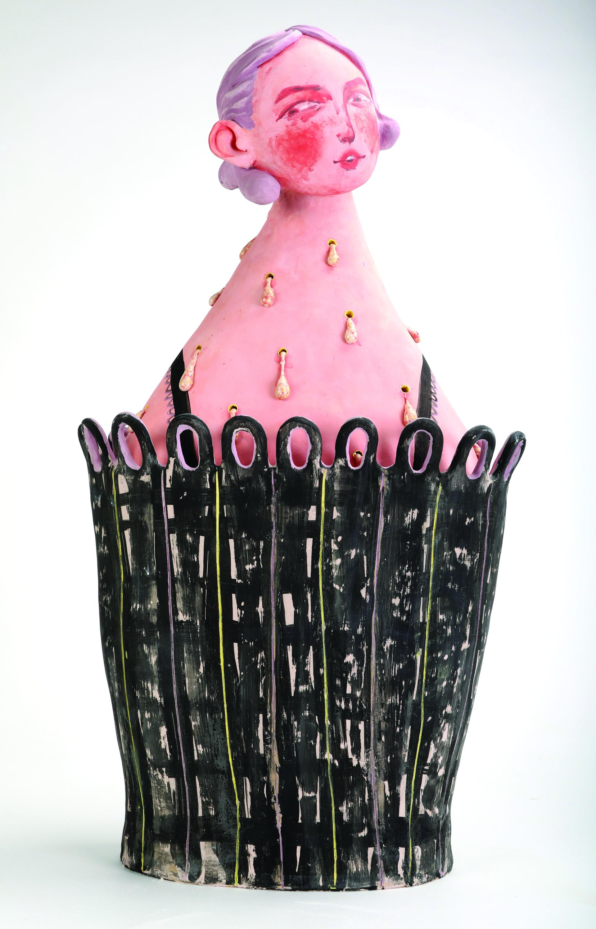 A ceramic figure with pink skin, purple hair, and a "knowing" expression.