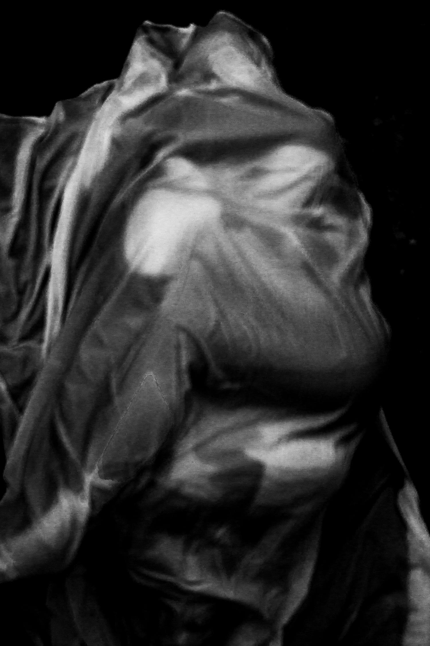 Two figures draped in fabric wrapping around each other.