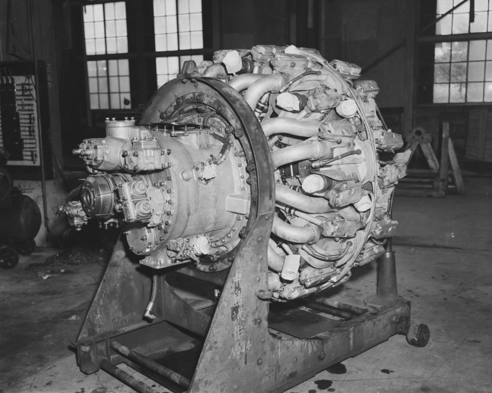 A black-and-white flash-lit photograph of the right-side posterior of a 1940's airplane engine.