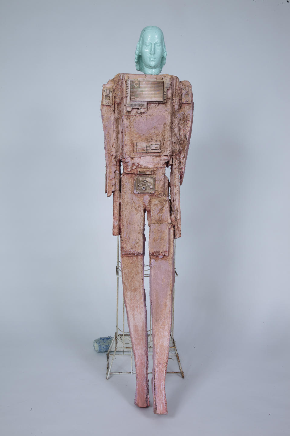 pink robotic figure leaning on wine rack