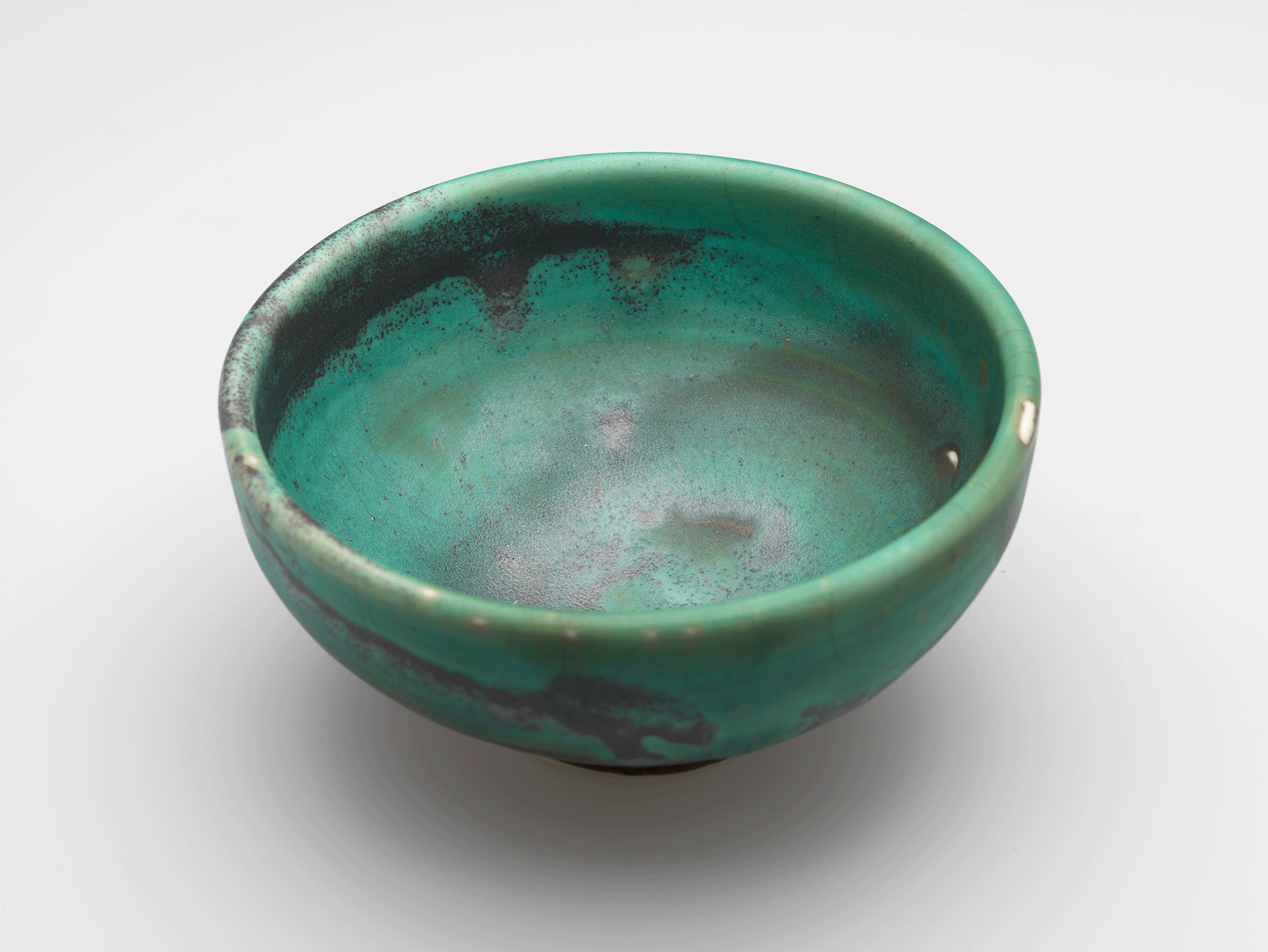 Interior view of green bowl with irregular splashes of dark gray