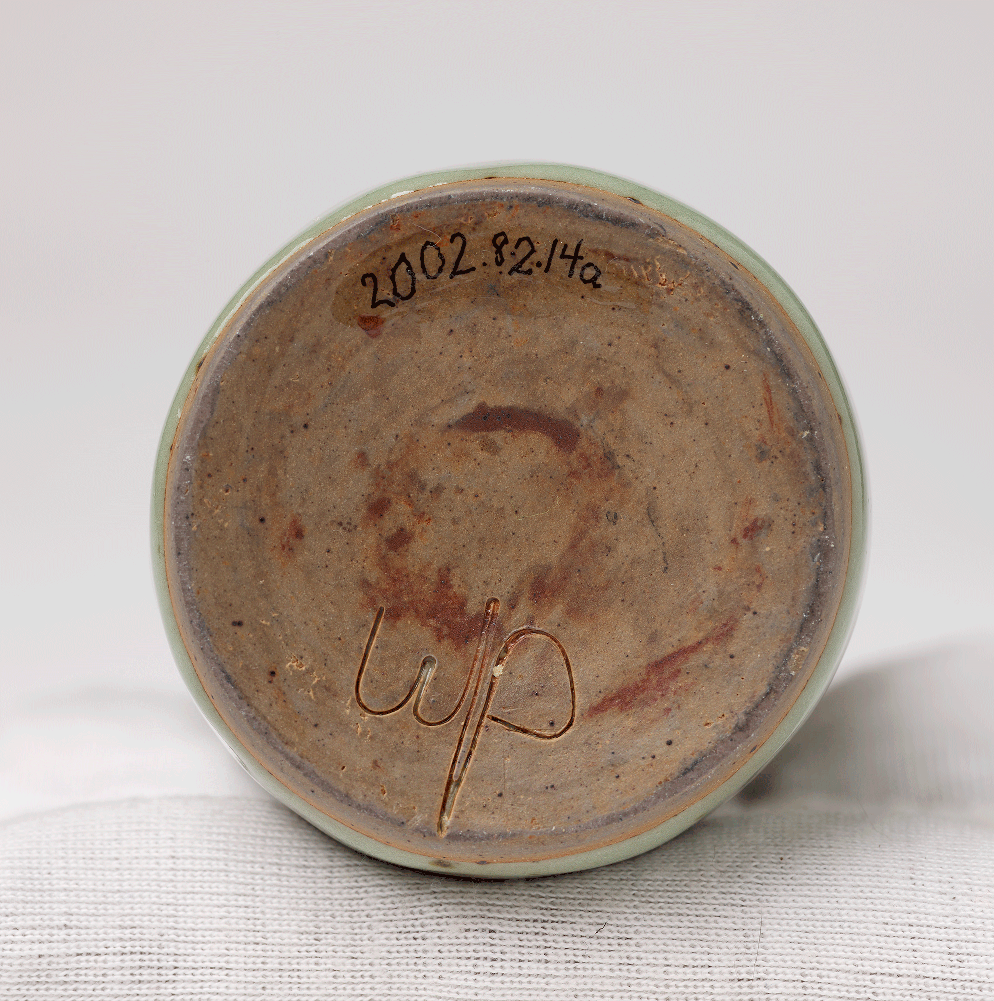 Underside of decanter. Letters “wp” are carved into the clay. Accession number is visible.