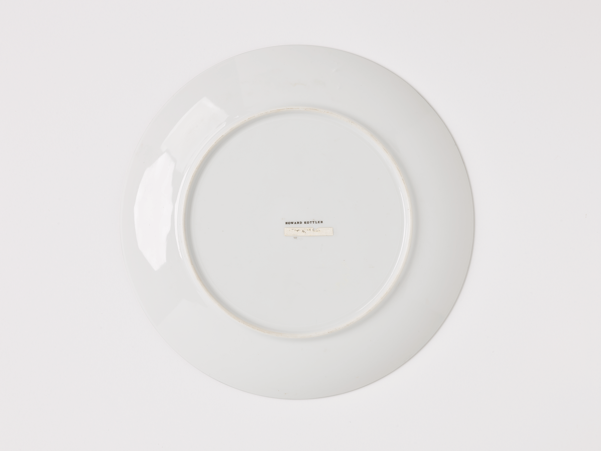 Underside of plate. Name printed in the center reads “Howard Kottler.”