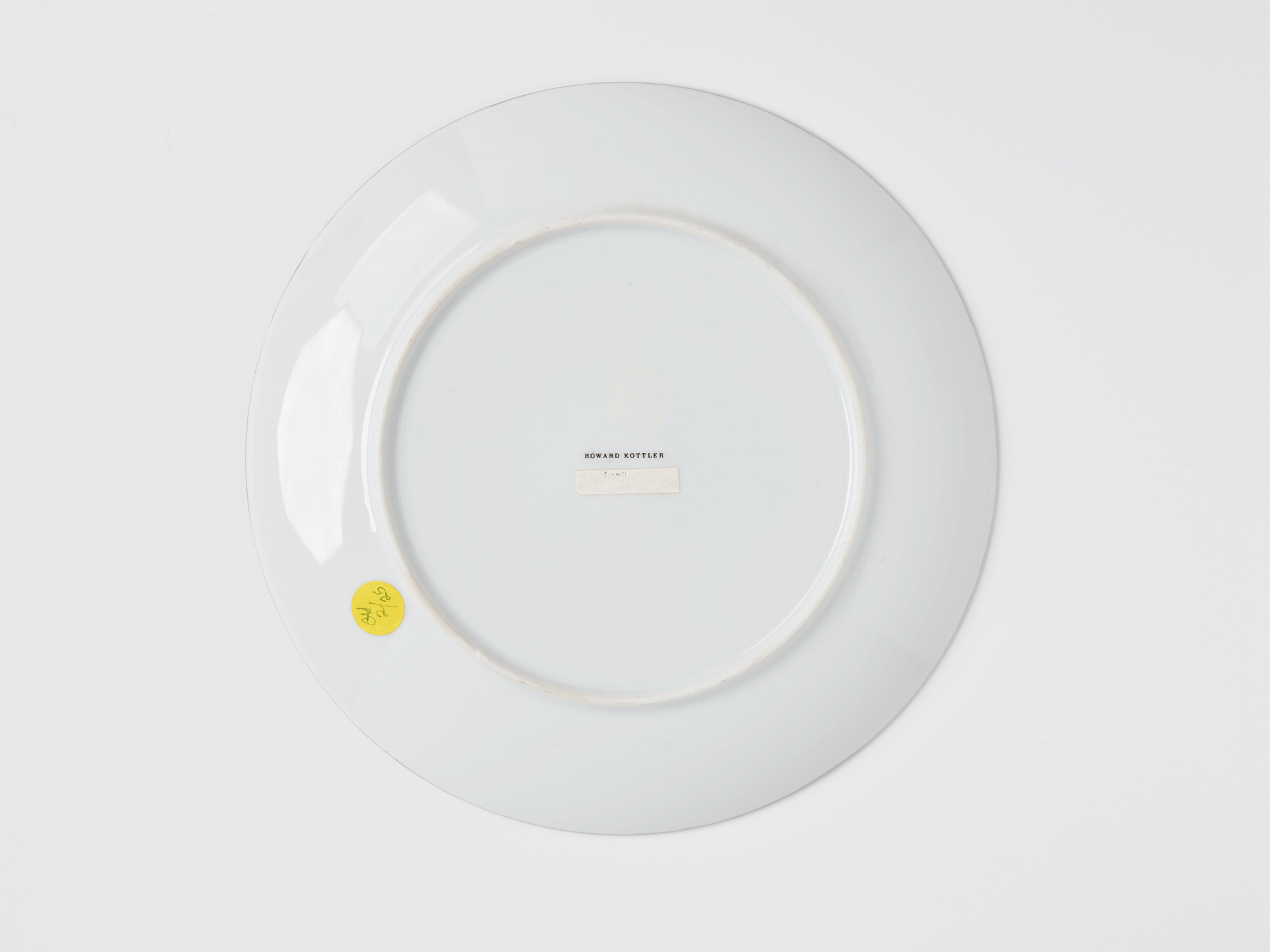 Underside of plate. Name printed in the center reads “Howard Kottler.”