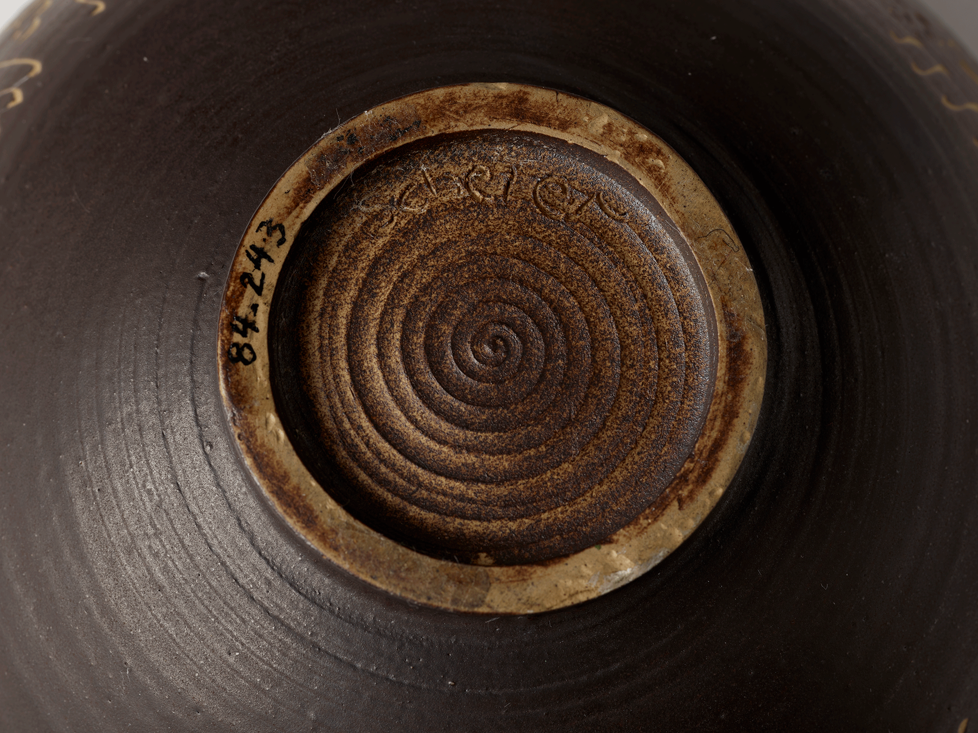 Underside of the bowl with the name “Scheier” scratched into the clay. Accession number is visible.