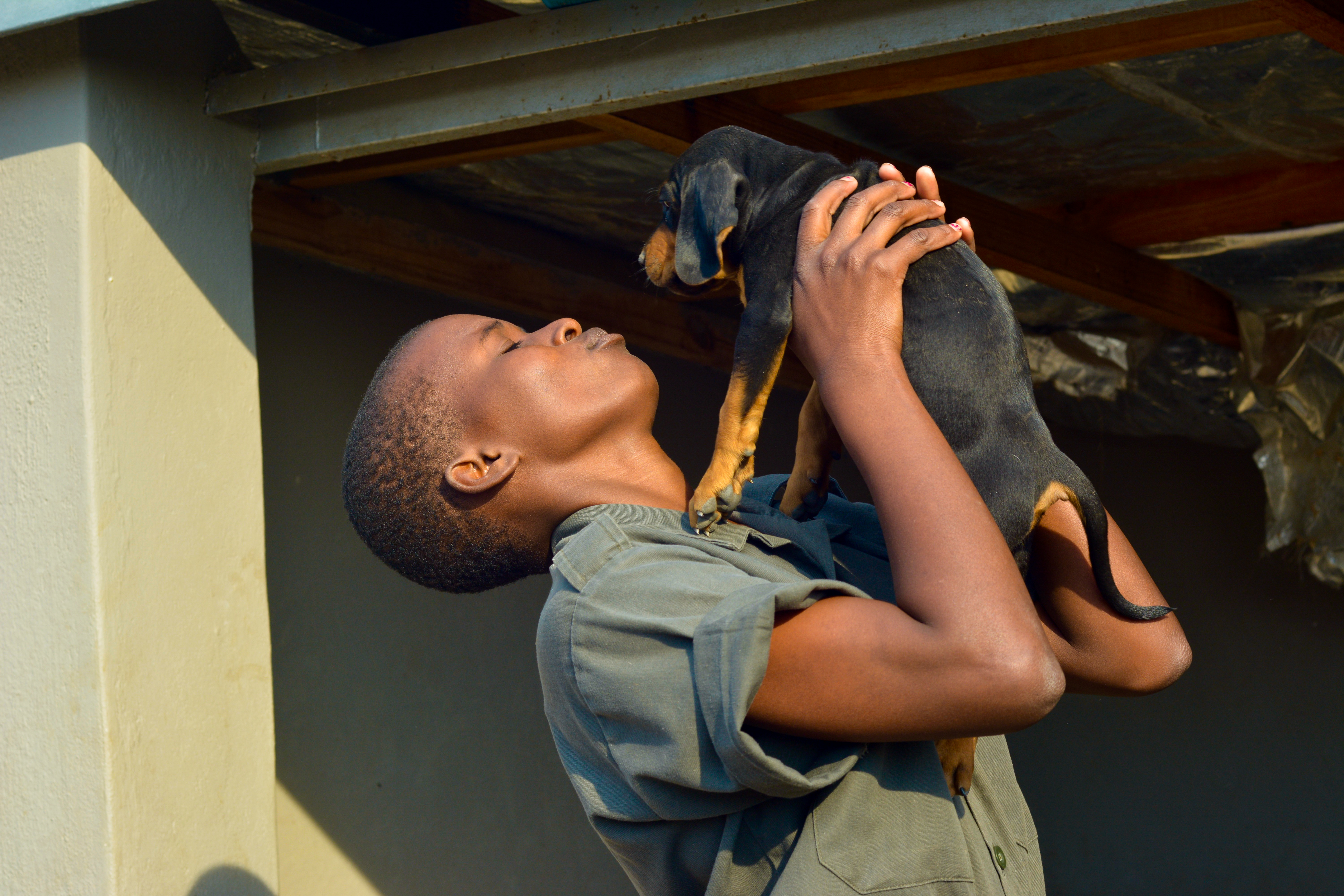 /Precious%2C%20an%20anti-poaching%20dog%20trainer%20holds%20up%20and%20kisses%20a%20new%20puppy%20from%20their%20team.