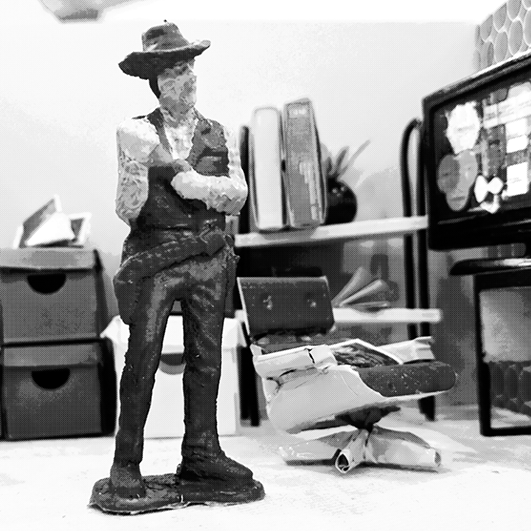 black and white photo of a sculpted cowboy figure surrounded by office furniture