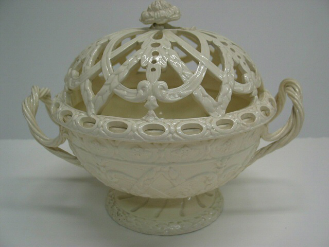 /A%20creamware%20chestnut%20basket%20with%20sculptural%20woven%20handles%2C%20sculpted%20foot%2C%20and%20the%20lid%20has%20decorative%20cutouts.%20