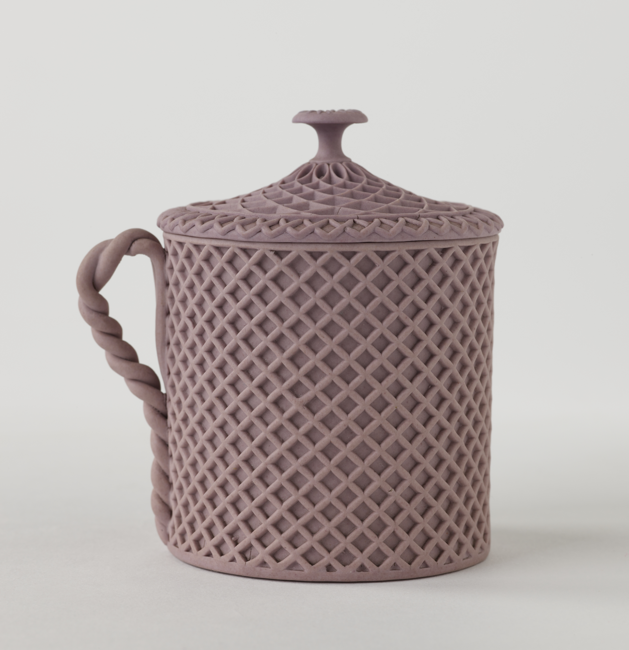 /Jasperware%20custard%20cup%20with%20cover%2C%20the%20entire%20vessel%20and%20lid%20has%20a%20raised%20woven%20texture.%20The%20handle%20is%20sculptural%20and%20swirled.