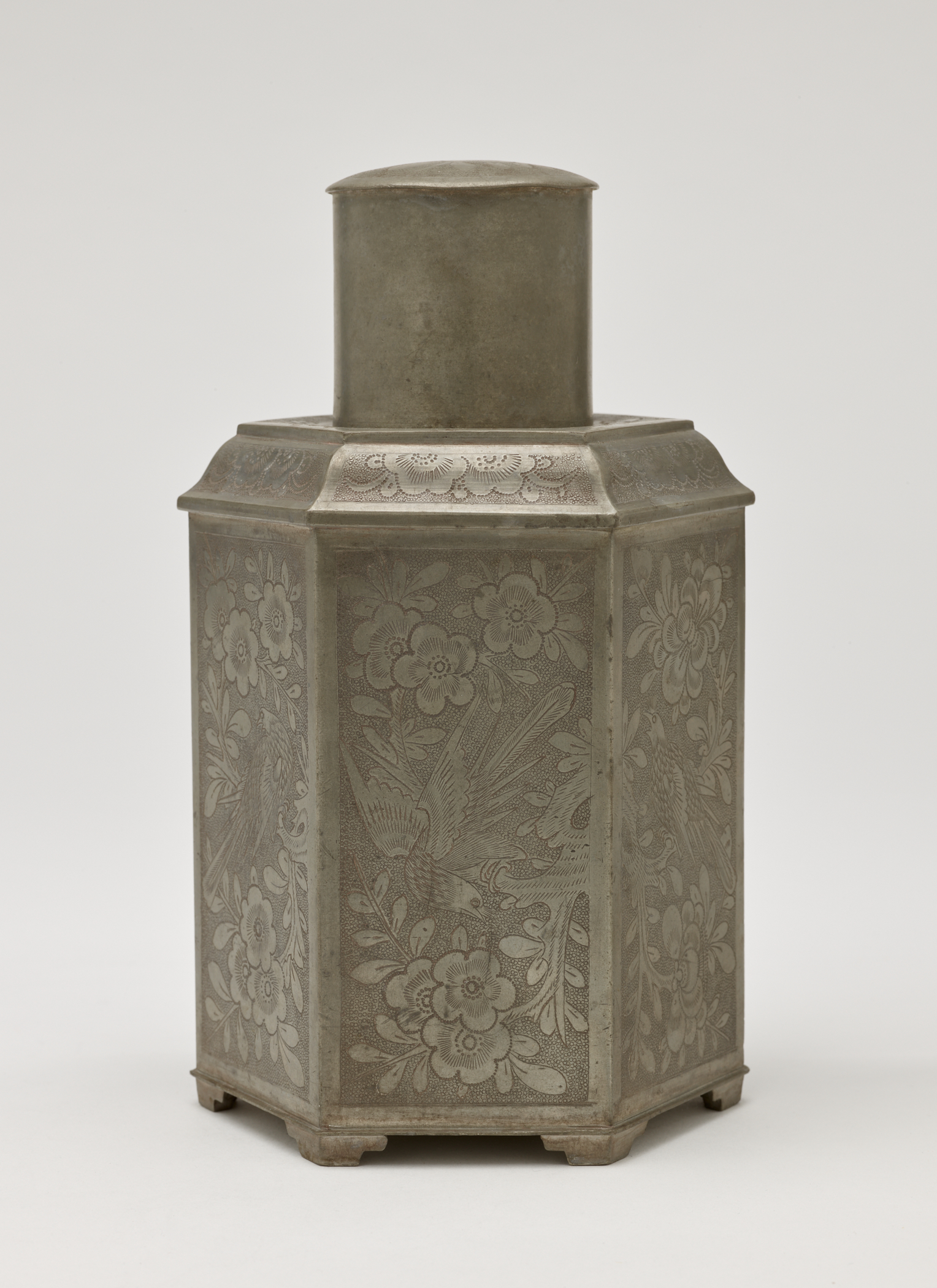 /A%20pentagonal%20pewter%20tea%20caddy%20with%20floral%20decorations.