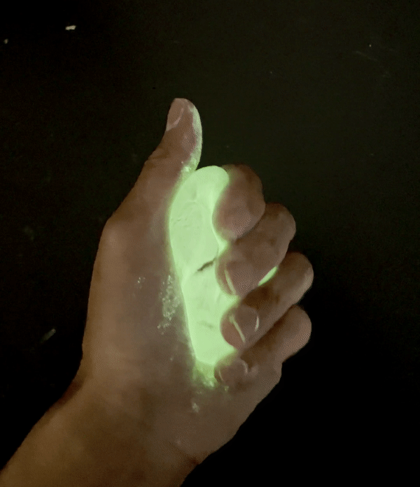 hand kneads a lump of glow in the dark clay