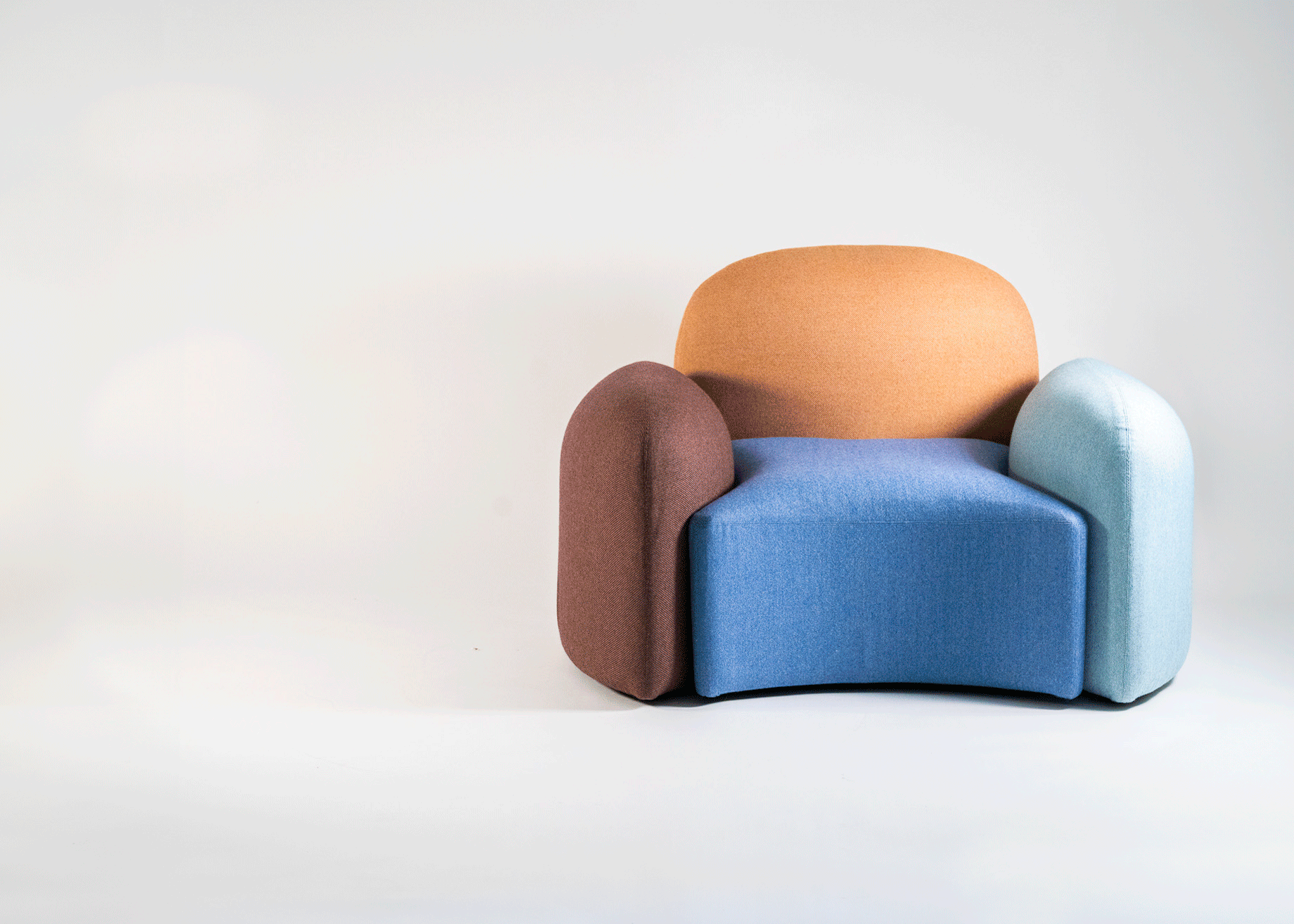 A moving gif showing a colorful, upholstered modular seating system expanding from an armchair to a wide sofa.