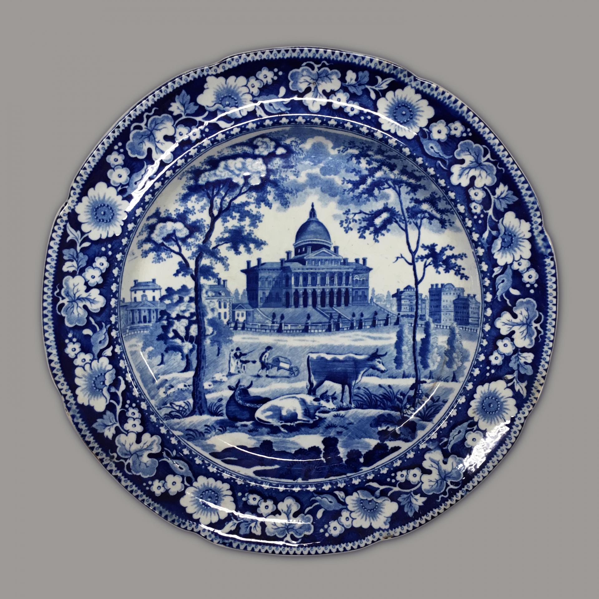 blue and white transferware plate depicting the Boston State House with cows in the foreground