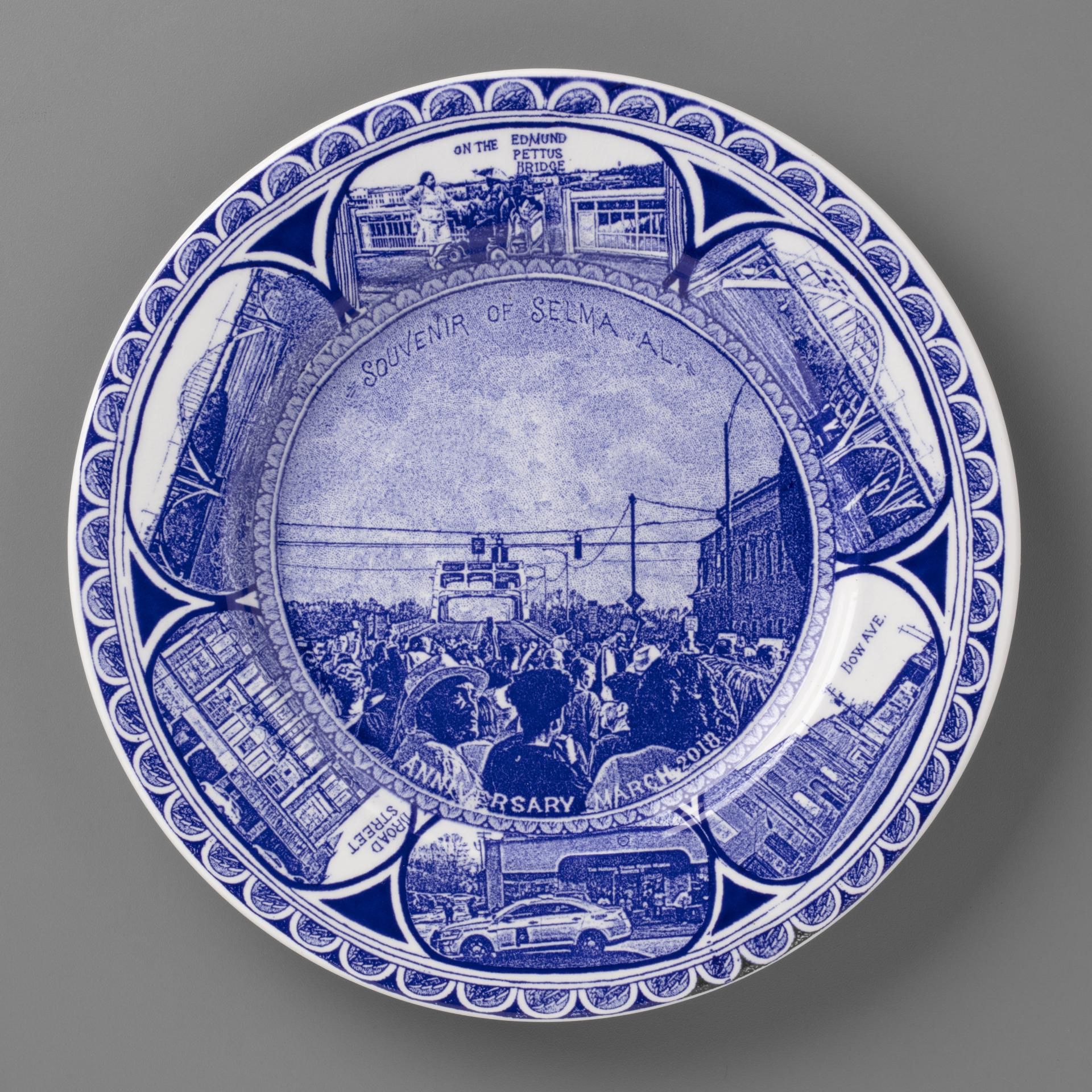 blue and white transferware plate depicting scenes of Selma, AL, featuring a march across the Edmund Pettus Bridge