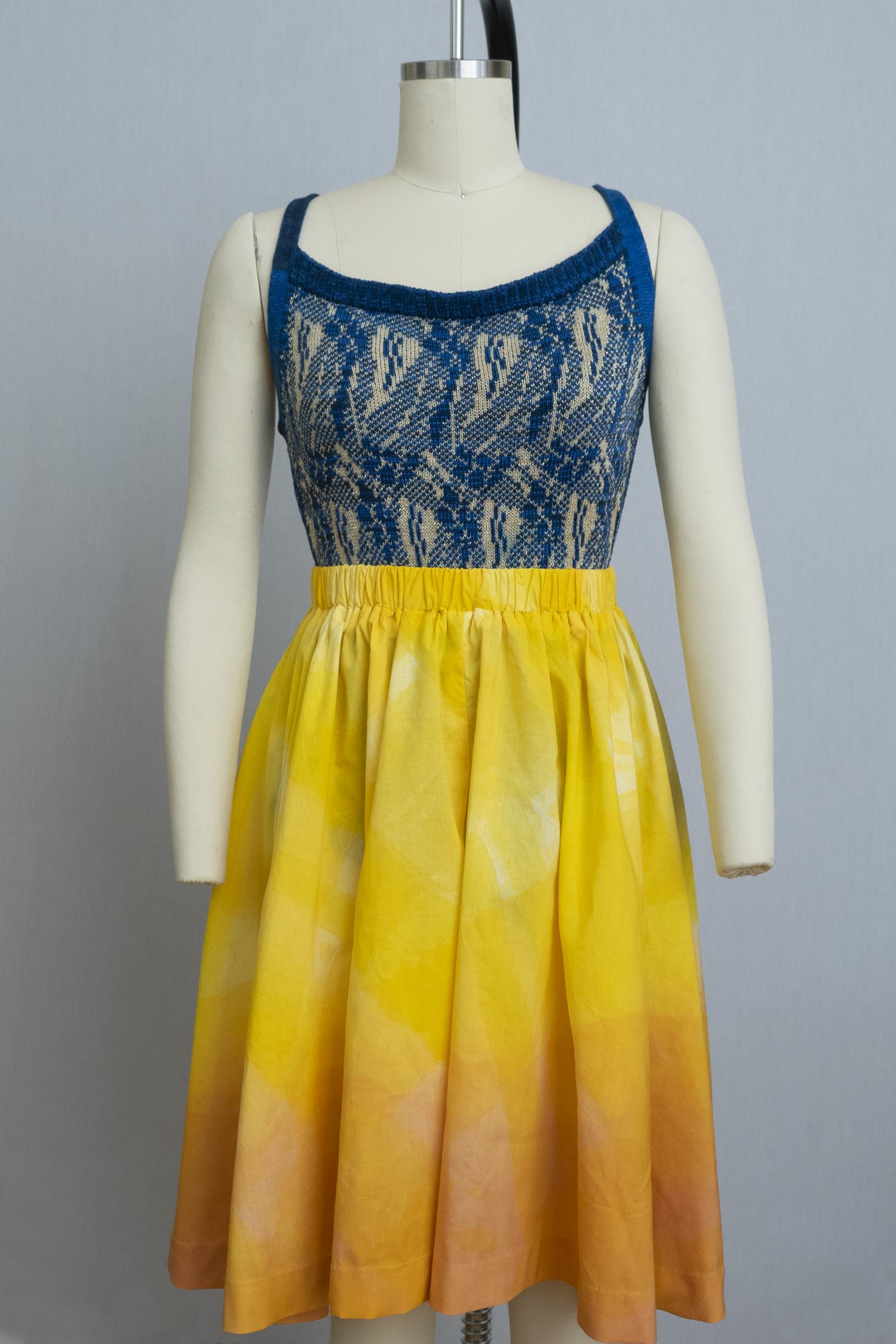 dress form wearing blue knit playsuit and wide leg pants in an orange-yellow ombre