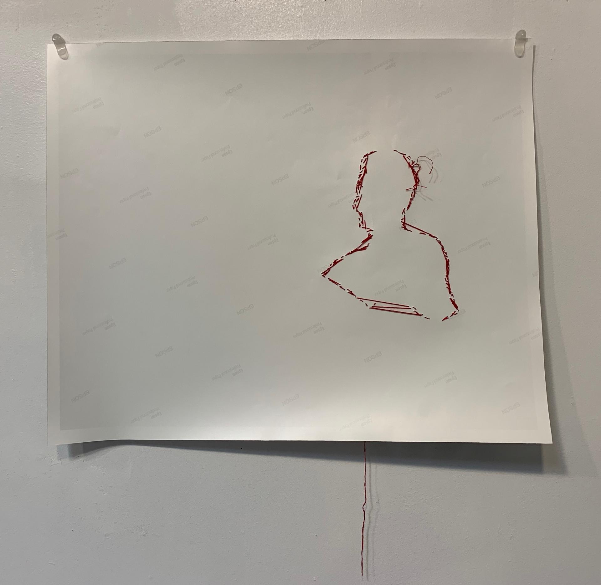 Red thread creates the outline of a figure on the back of photo paper