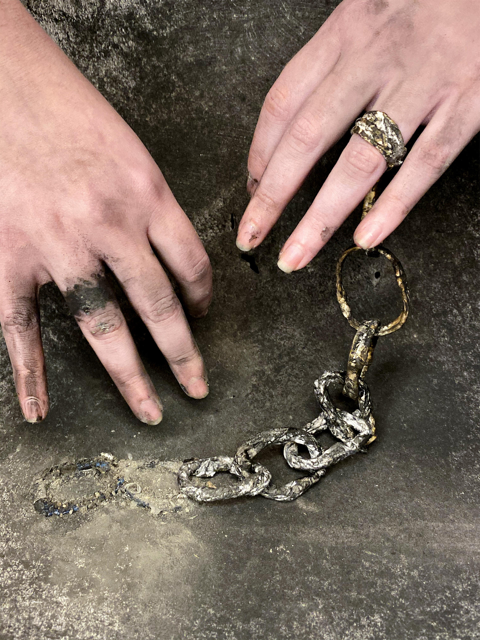 Hands with a chain and charcoal