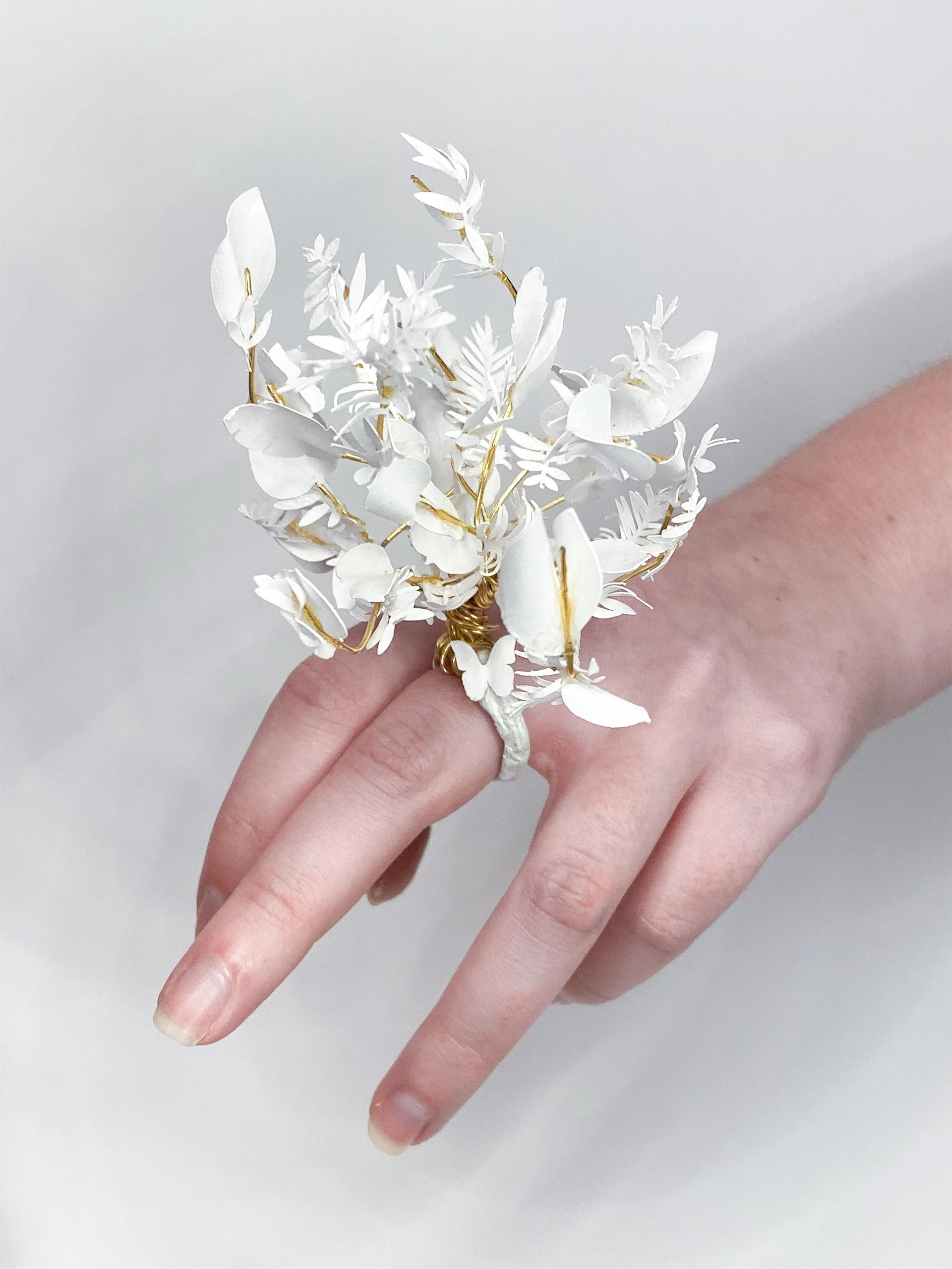 Hand with a sculptural floral ring made of paper and wire