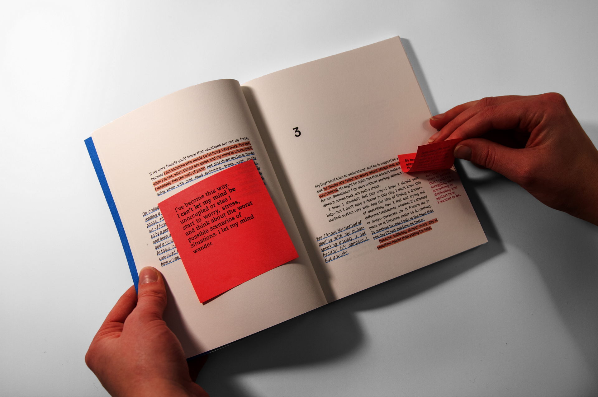 Hands holding an open book spread with post-it notes and highlighted text