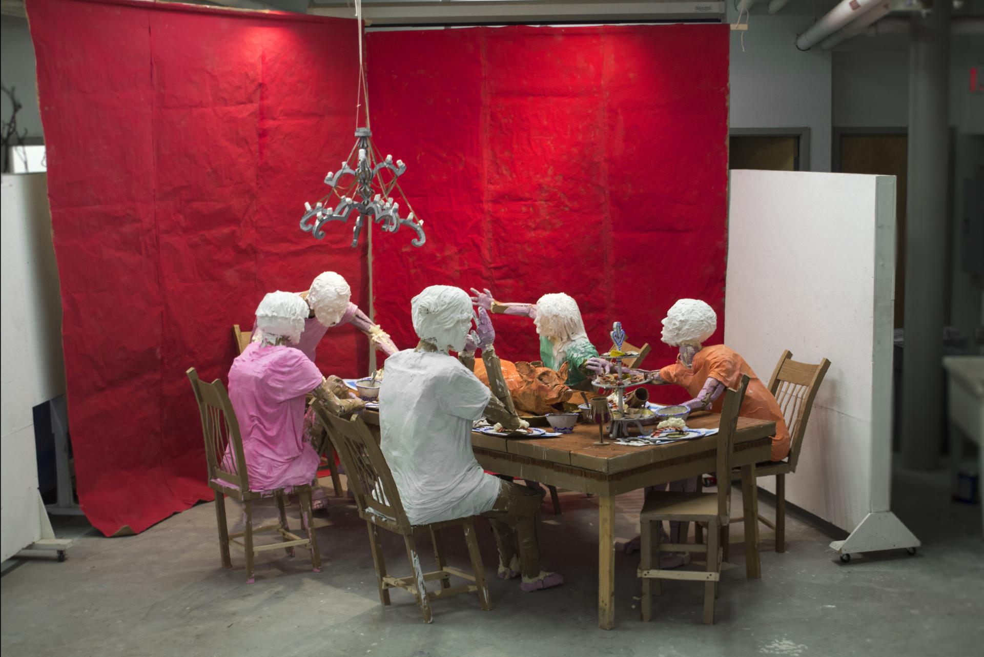 Installation of a group of people around a dinner table