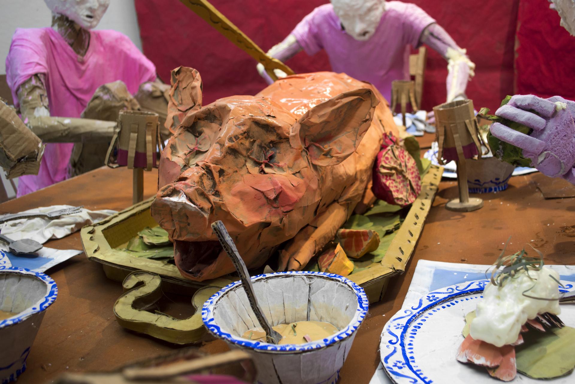 Installation sculpture of a group of people sitting around a dinner table.