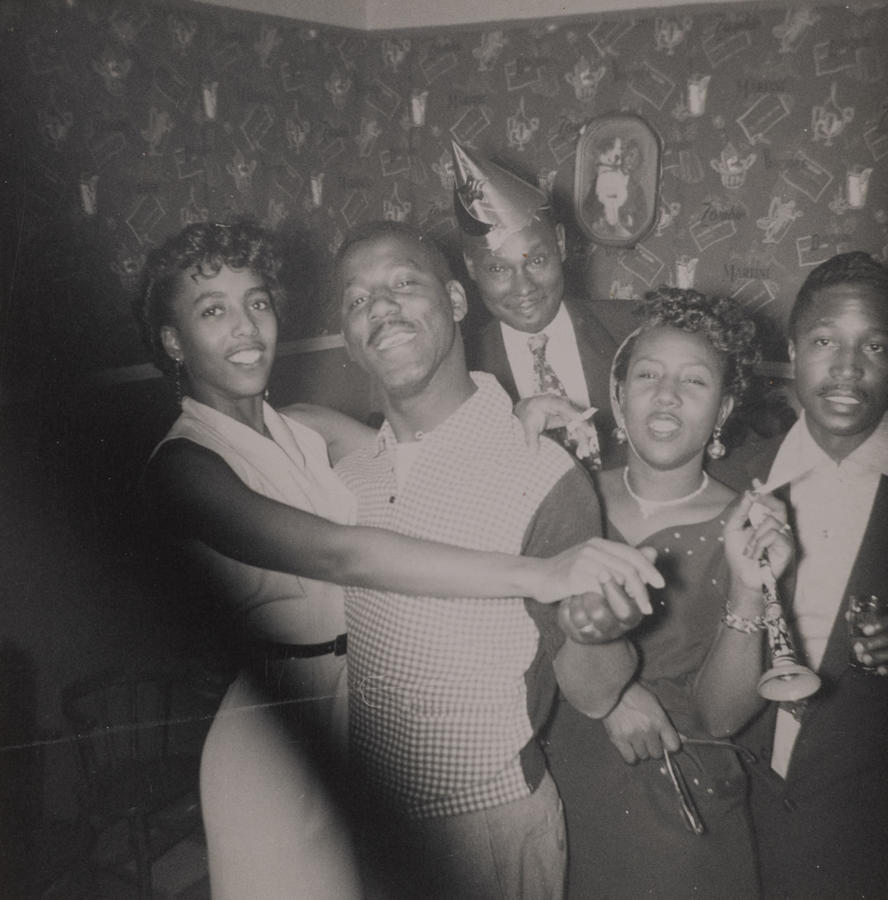 Black & white snapshot of a five young Black folks at a party