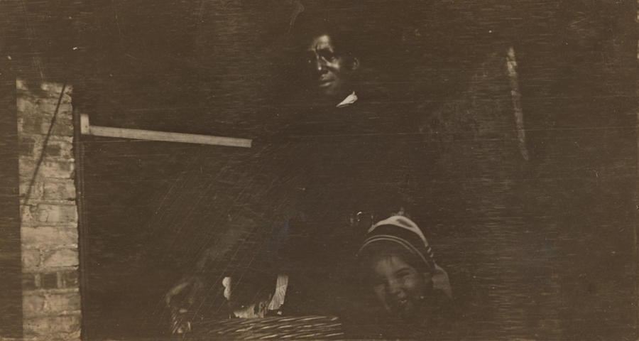 Black & white photograph of a black man standing with a child
