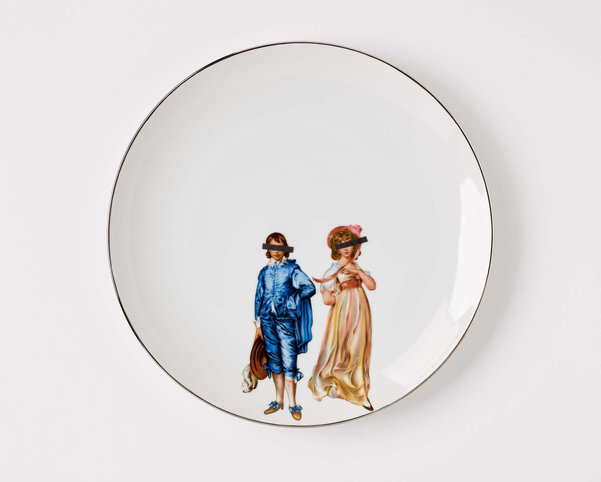 A white ceramic plate with an illustration of a Victorian-style man and woman with black bars covering their eyes
