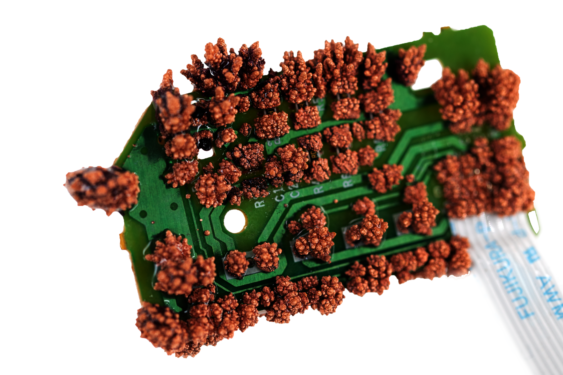 green circuit board with copper crystals growing on it