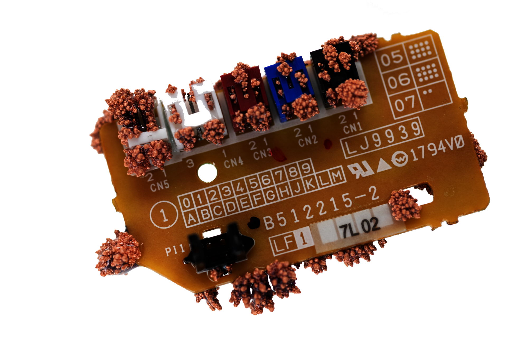photograph of a small circuit board with copper crystals growing out of it