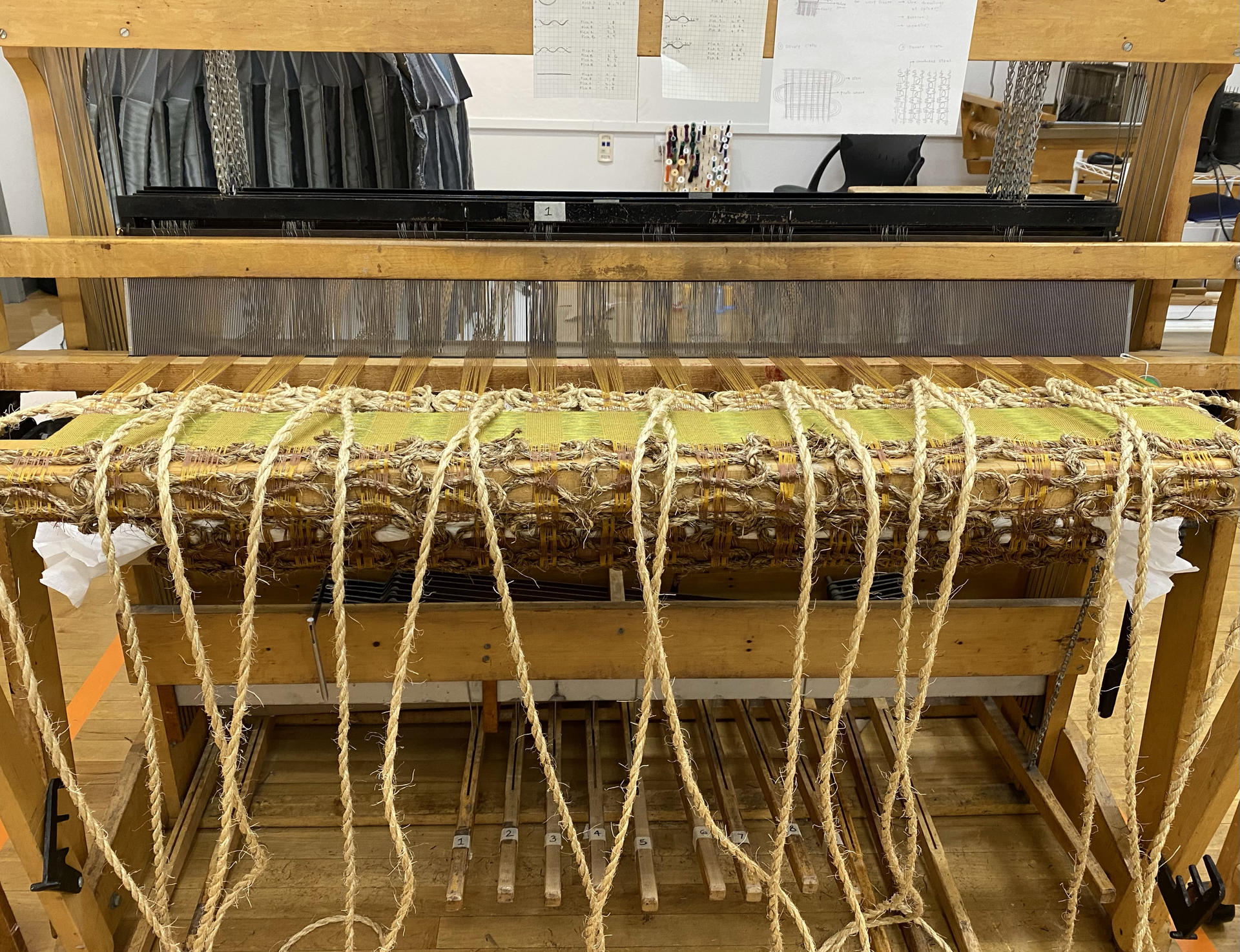 Image of the loom with handwoven piece on it