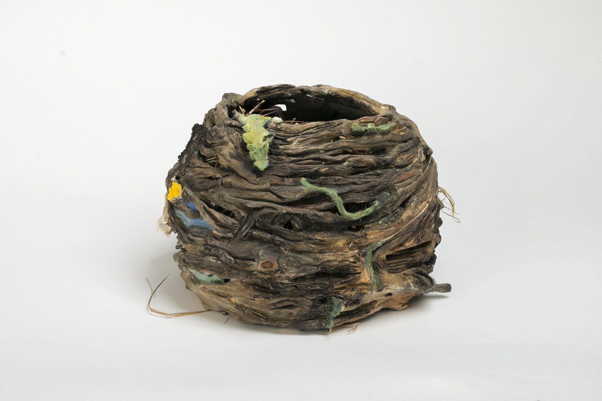 Ceramic nest sculpture with cattails and dandelions..
