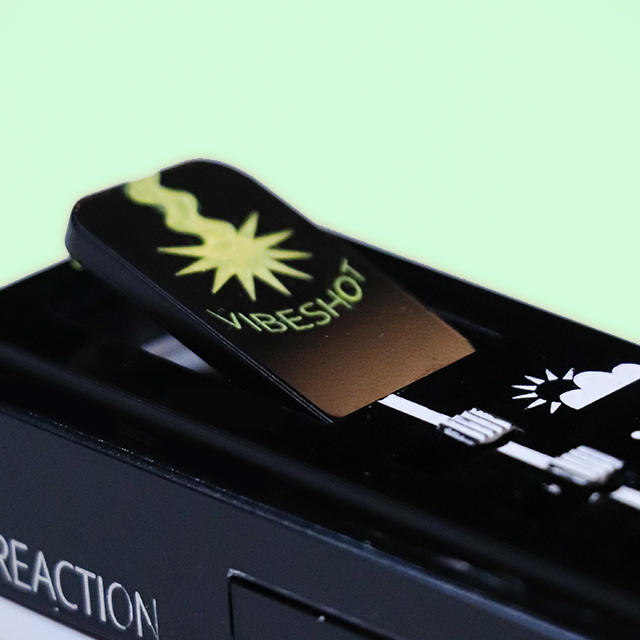 Closeup of the Vibelist feature: the vibeshot button is shown protruding from the surface