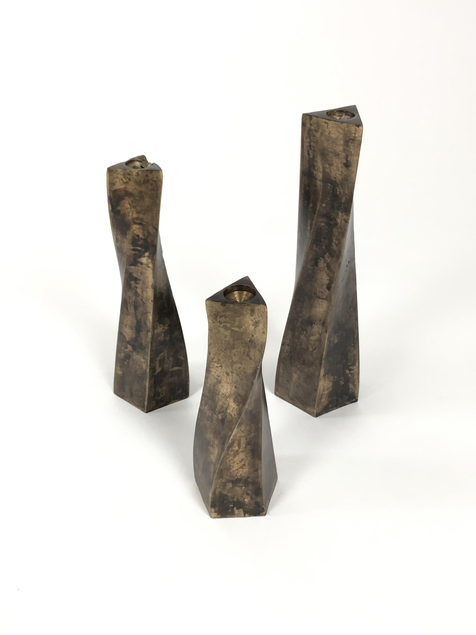 three bronze candle stick holders