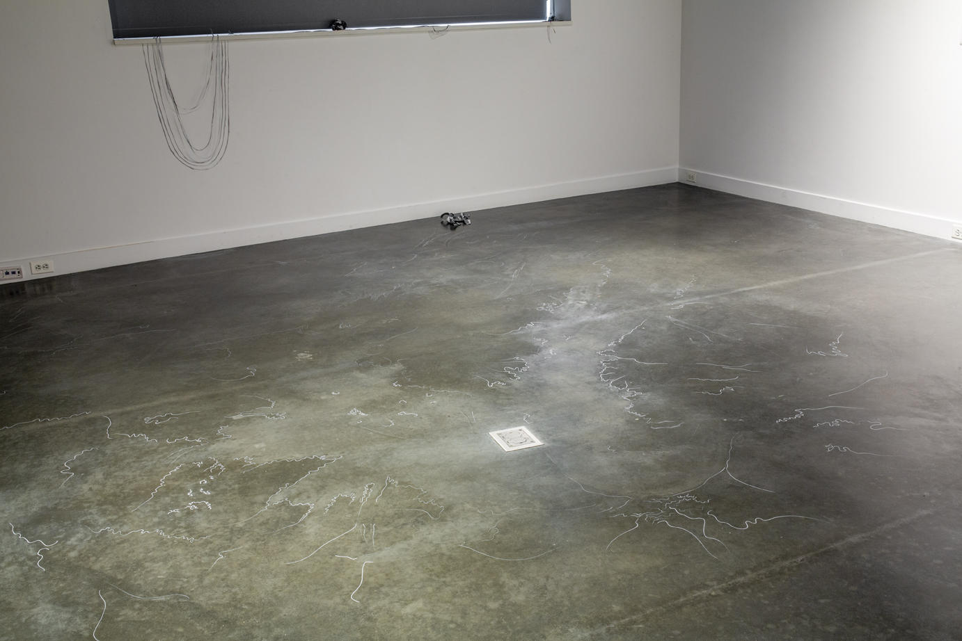 concrete gallery floor with thin white lines, as if salt water dried on the floor