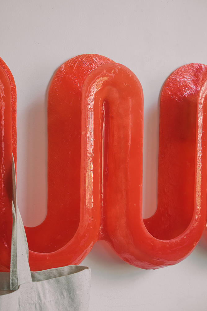 Detail image of red swell wall hooks. 