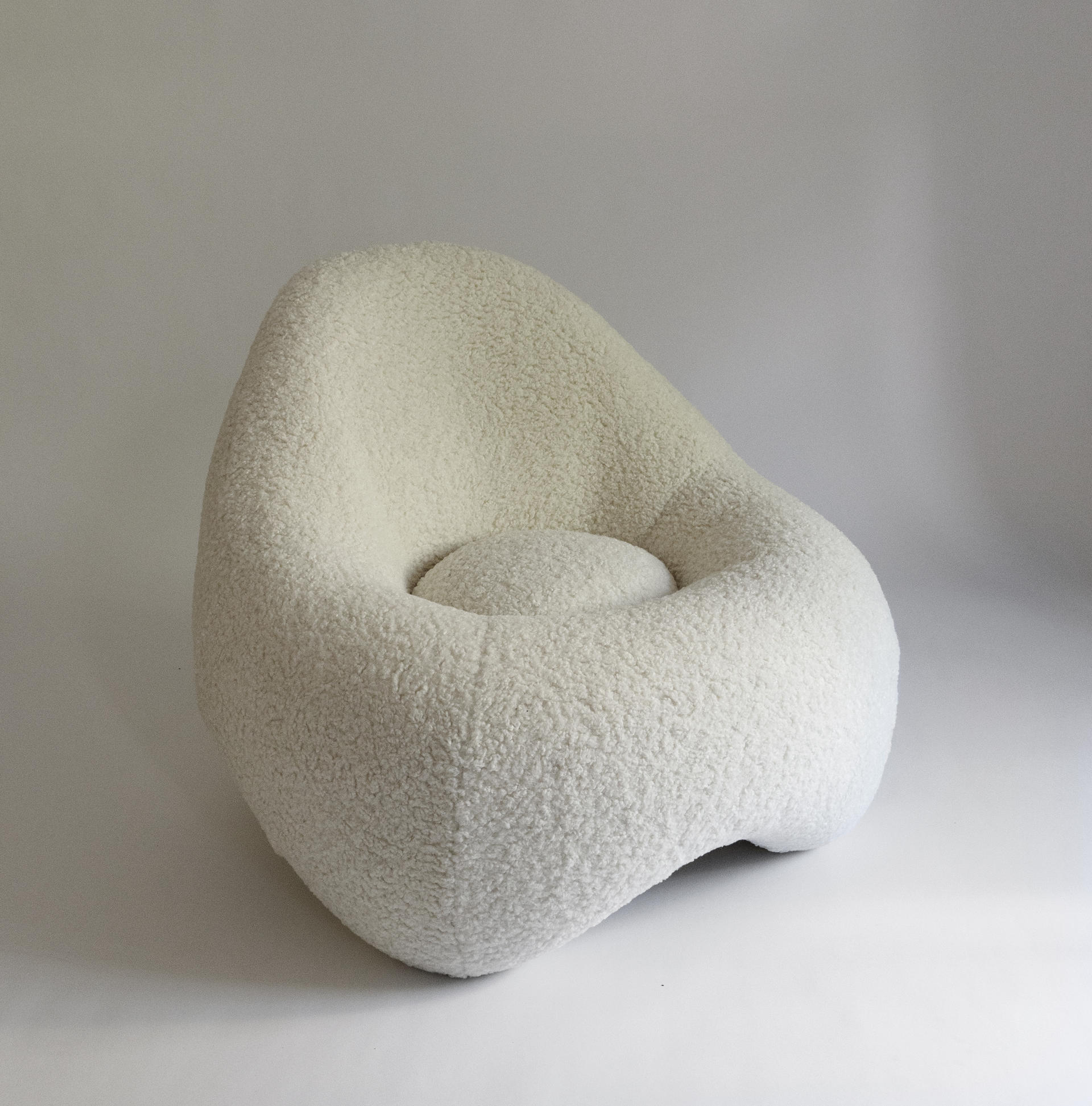 a soft, frame-less shape low lounge chair upholstered in sherpa