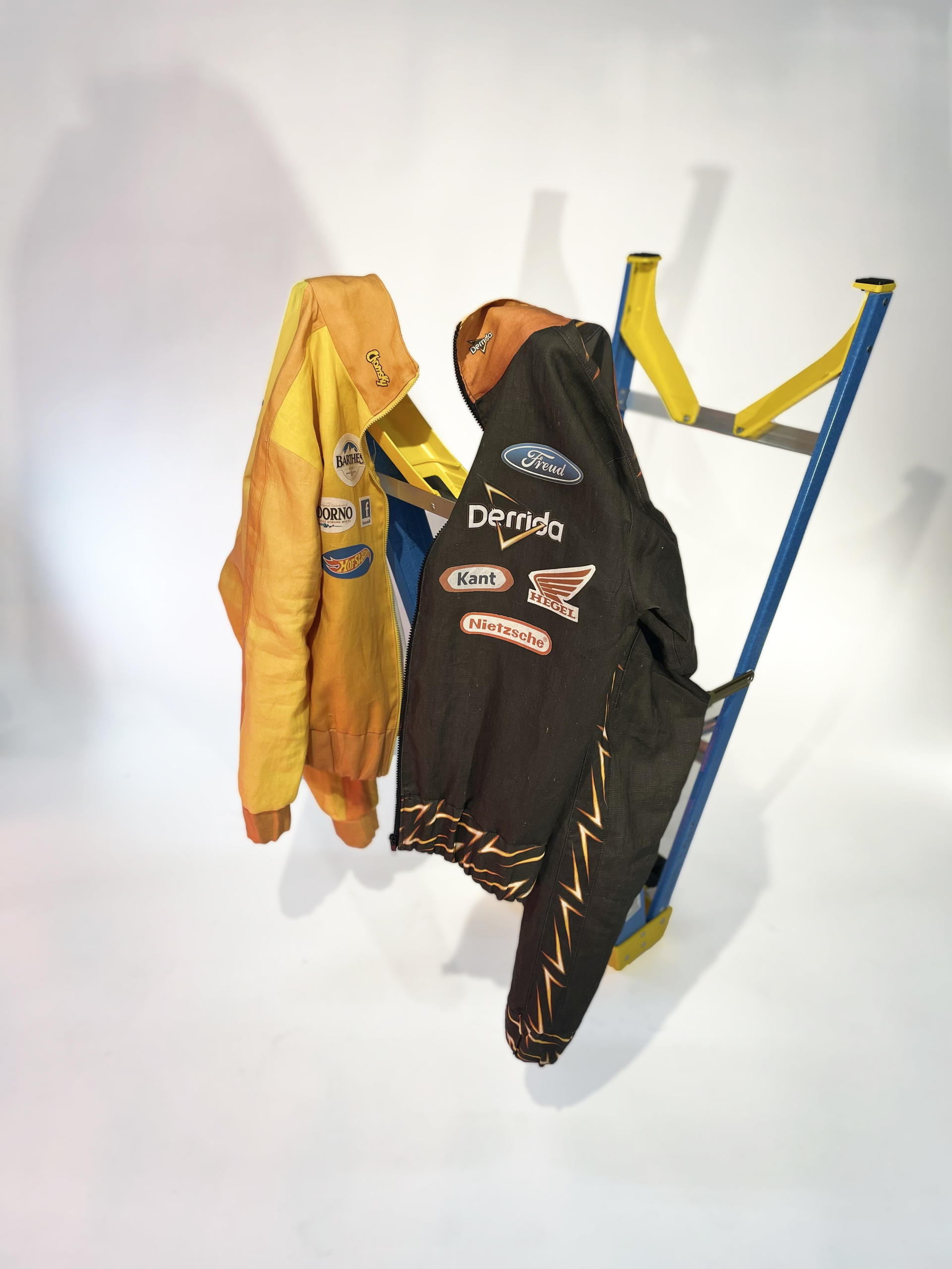Two NASCAR style jackets with logos edited to replace brand names with theorist's names.