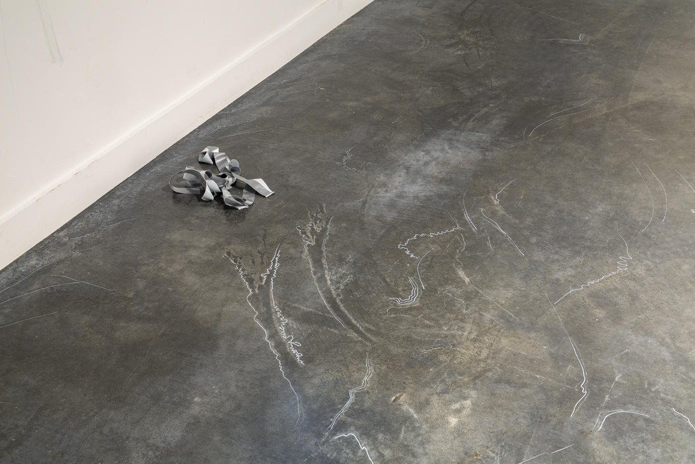 a pile of blue painter's tape on a concrete gallery floor