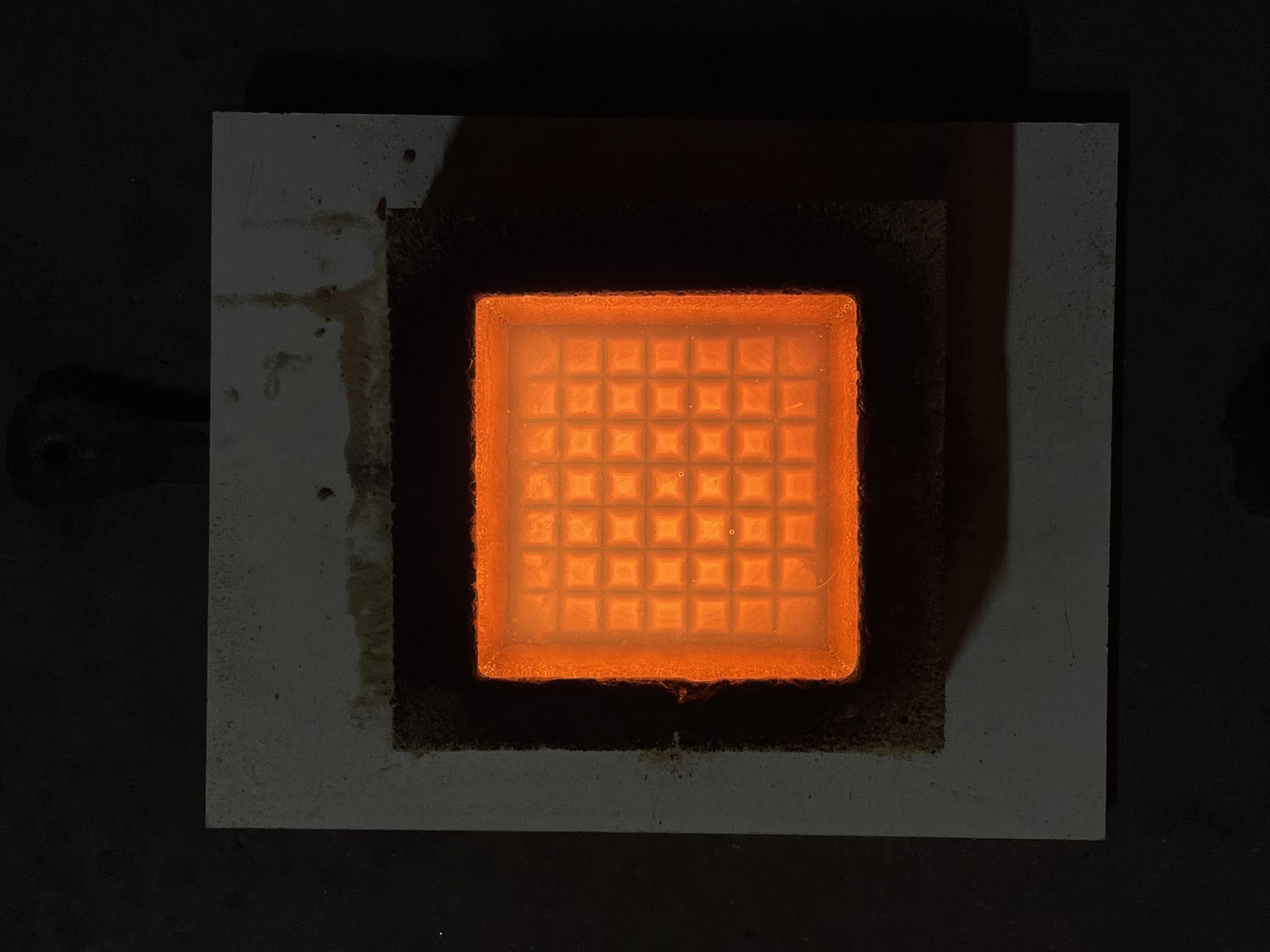 Molten glass poured into an optical grid mold.