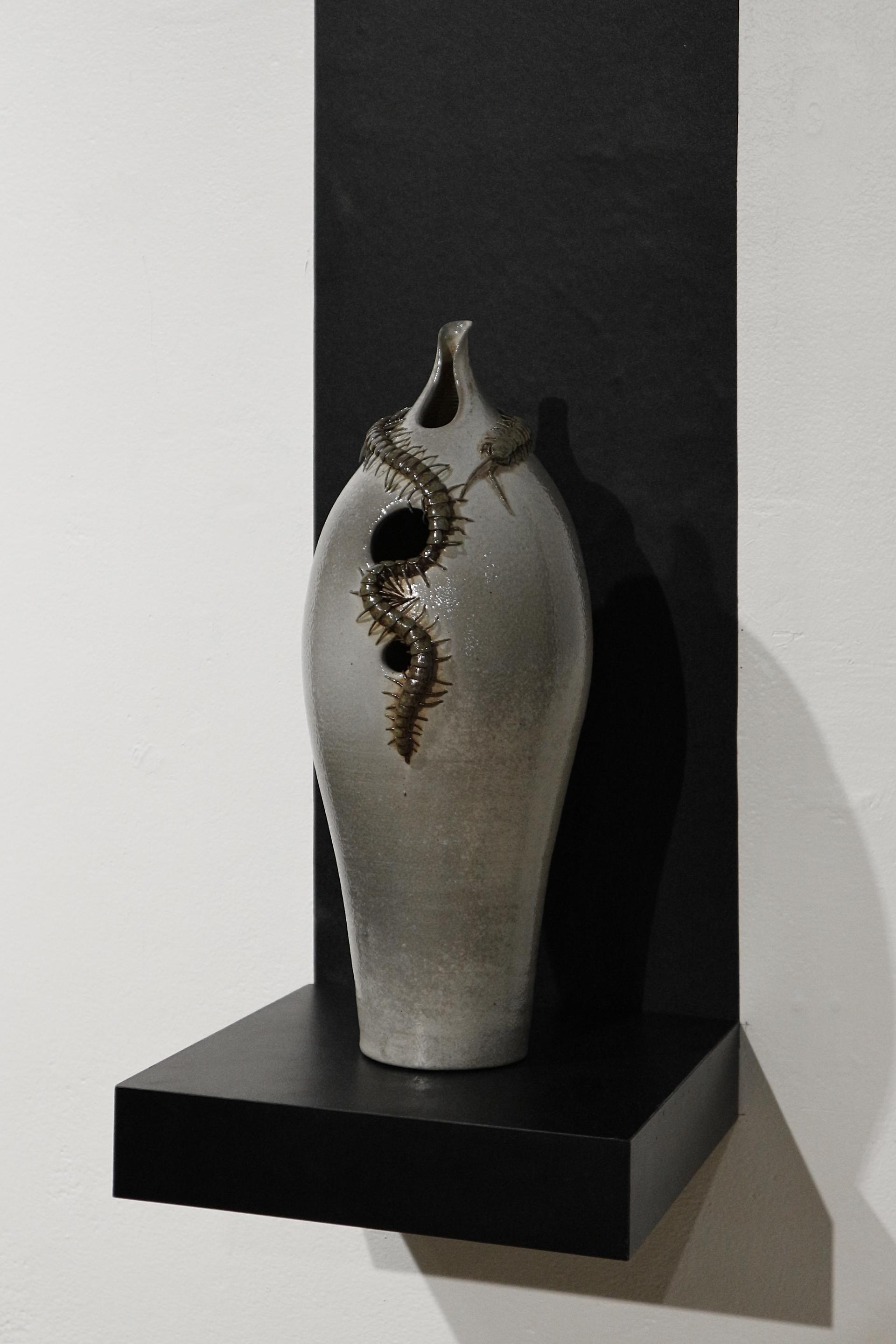 Soda-fired ceramic vessel with a hand-sculpted centipede around the neck.