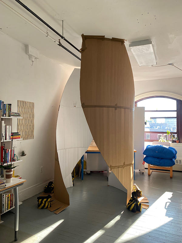 A one to one scale cardboard mock up of a monument in an artist's studio