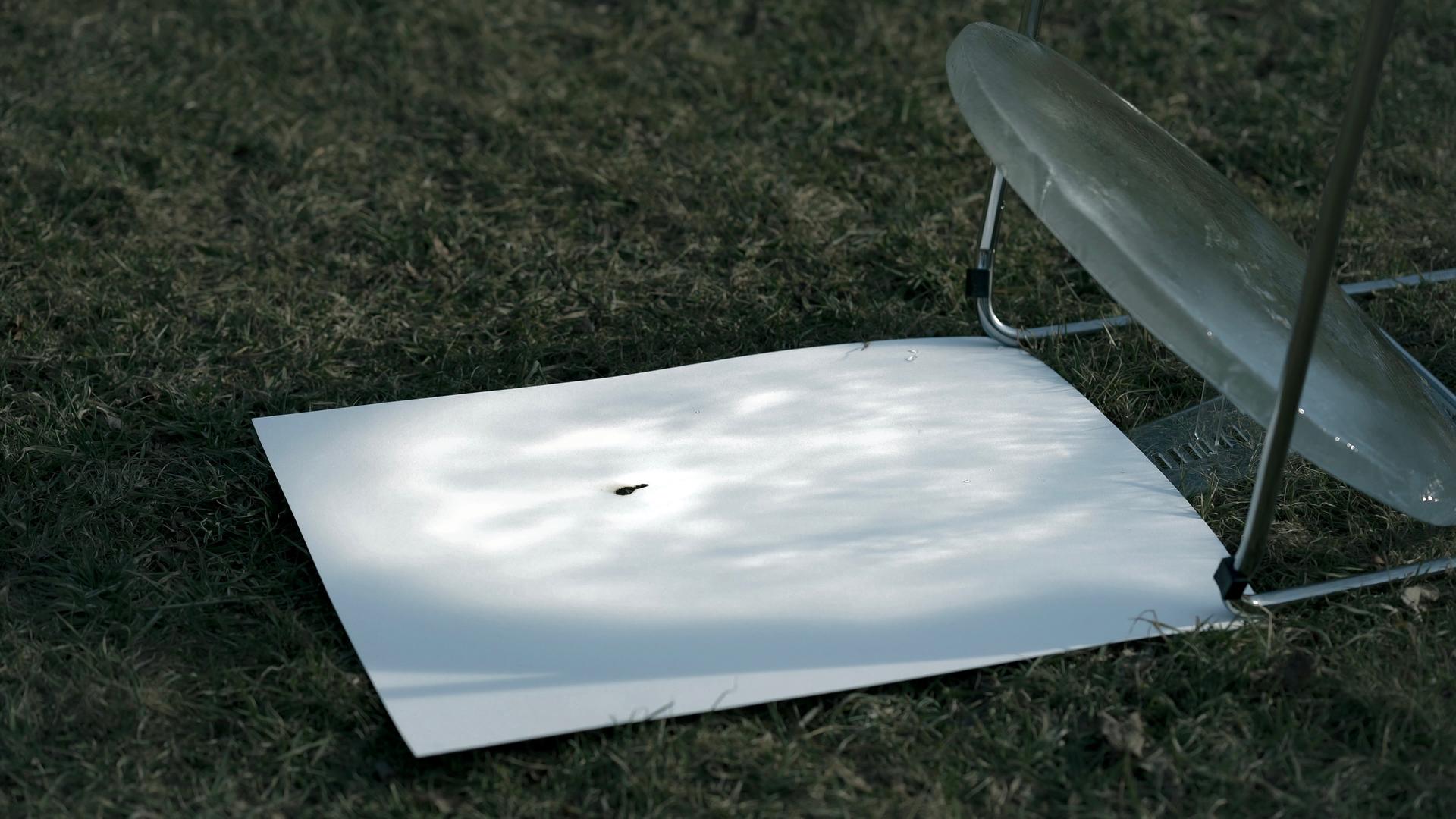 The ice lens burns the paper, the burn mark expanding as the sun moves.