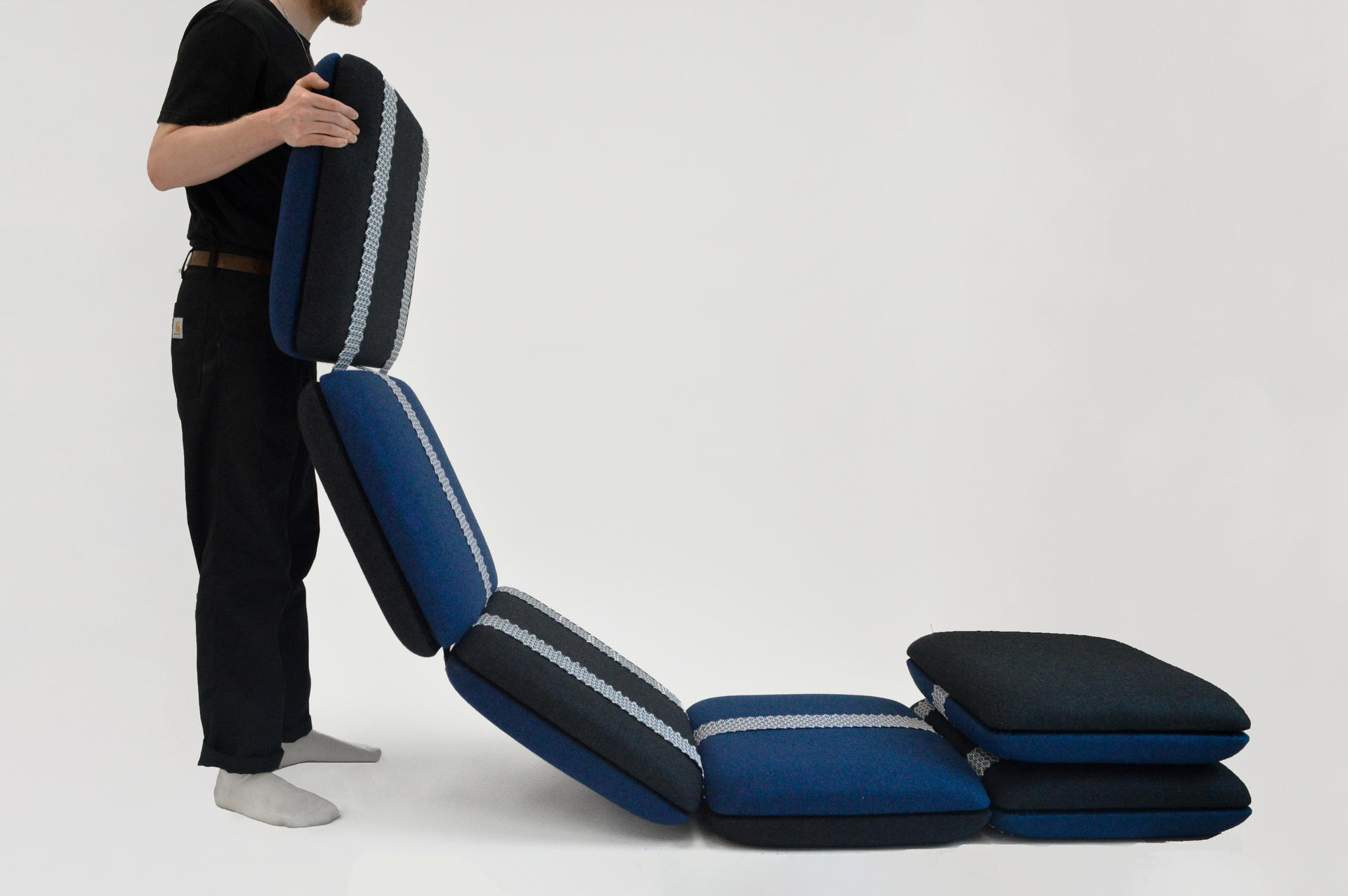 A flexible seating system comprised of tiled upholstered cushions and held together with webbing. 