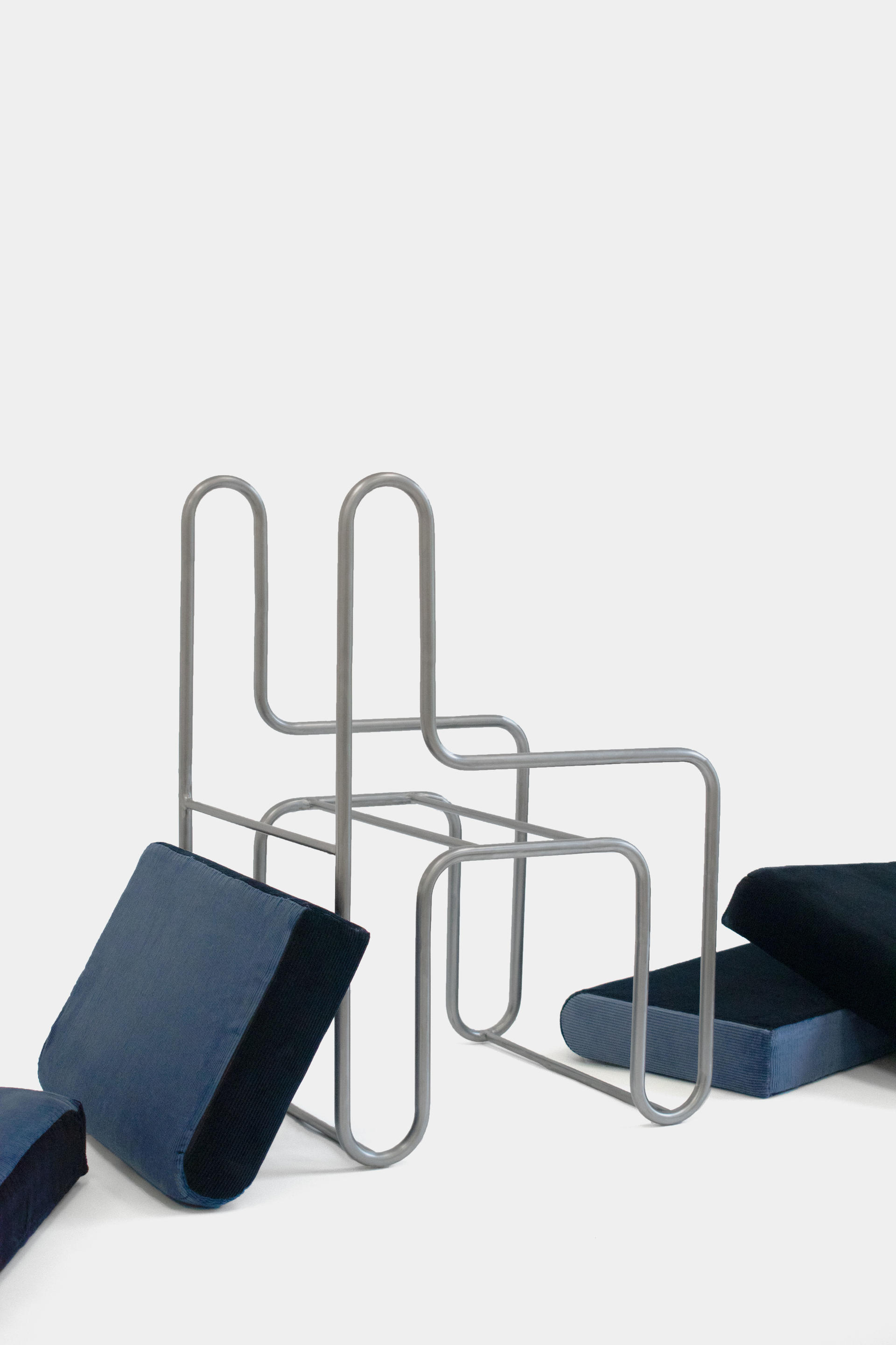 A chair built of upholstered pieces that press fit into a steel structure.