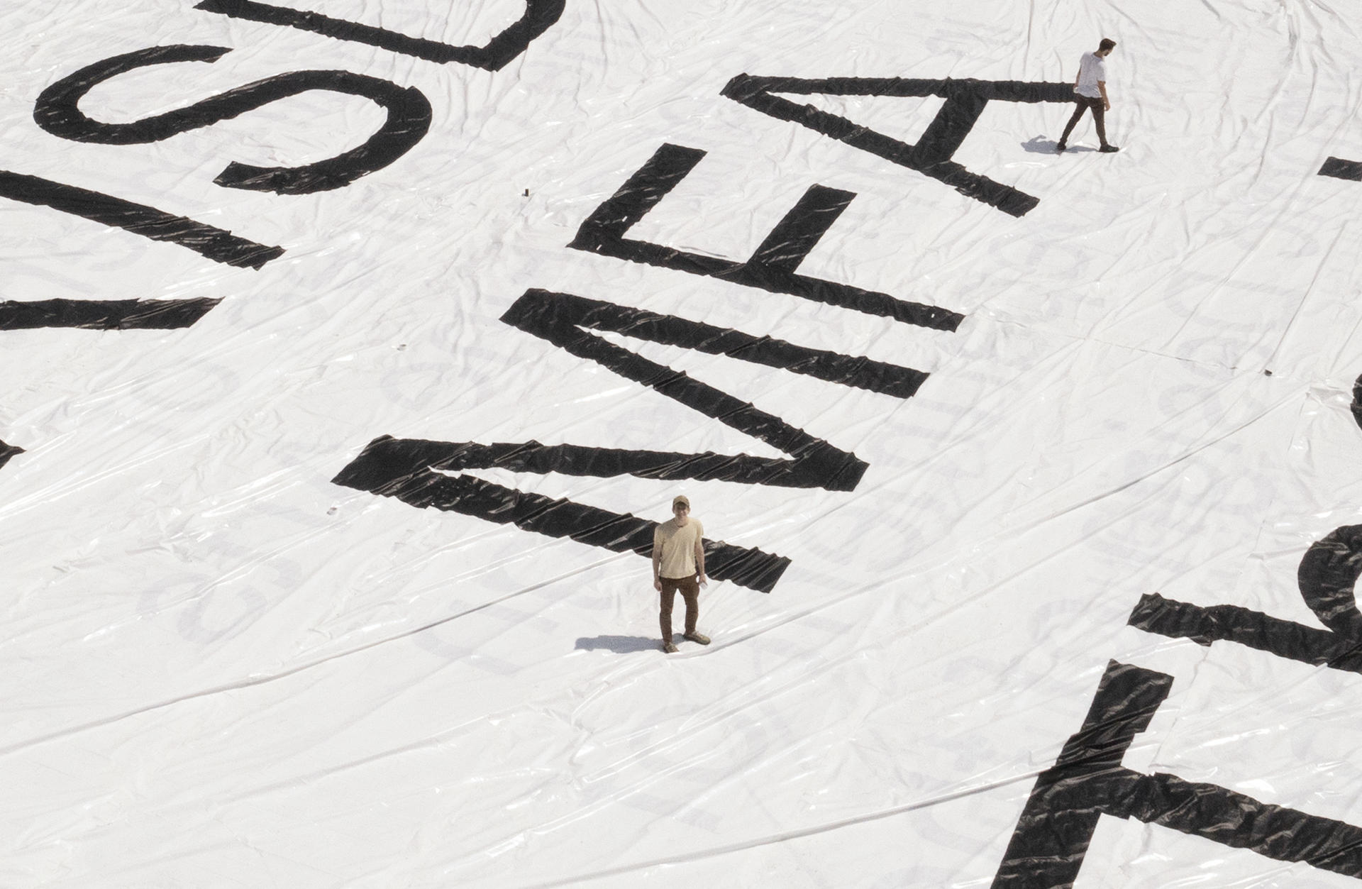 Ben Denzer standing on cover of his 200 x 125 ft RISD MFA Thesis book 