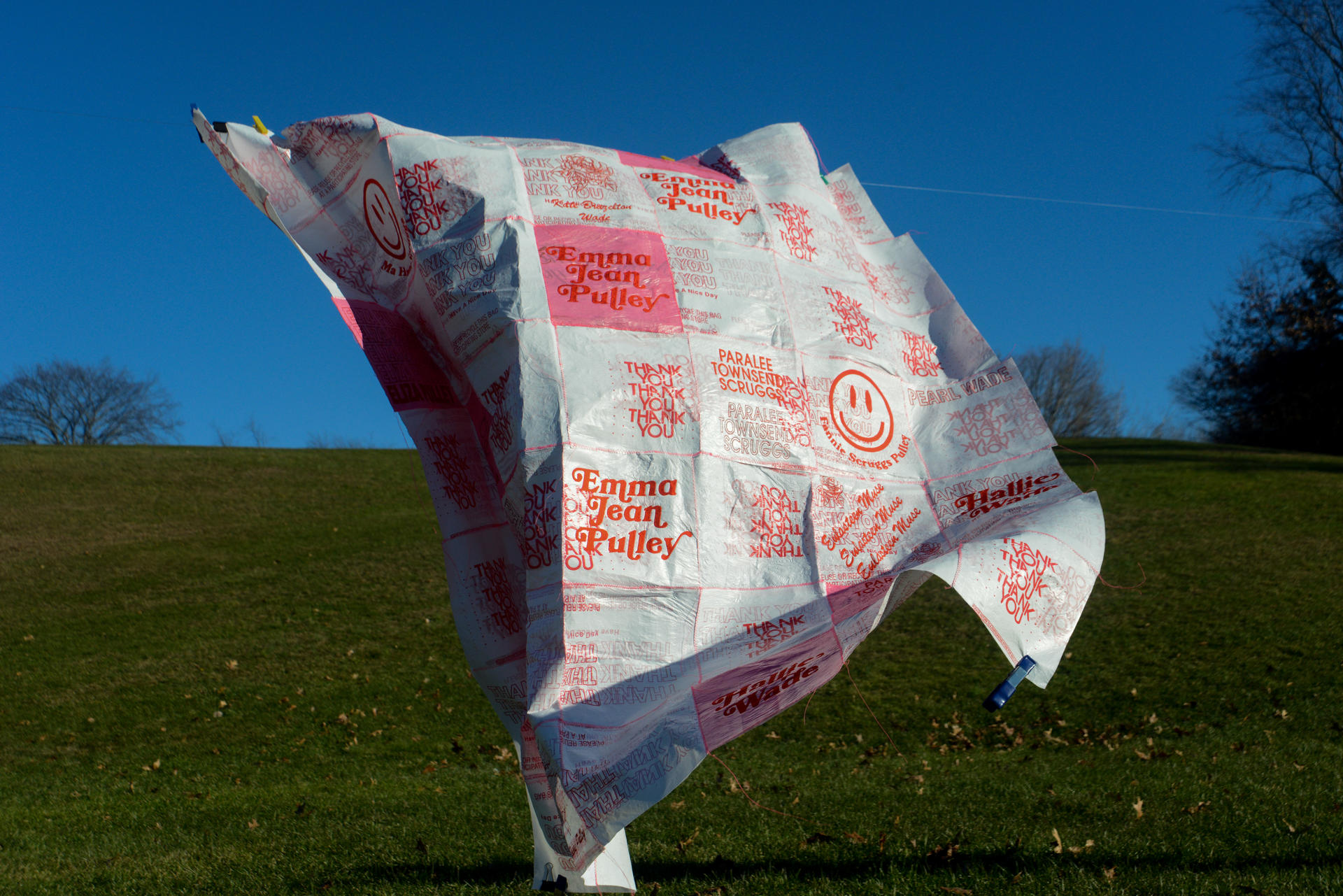 A white textile made of plastic bags with red-colored graphics.